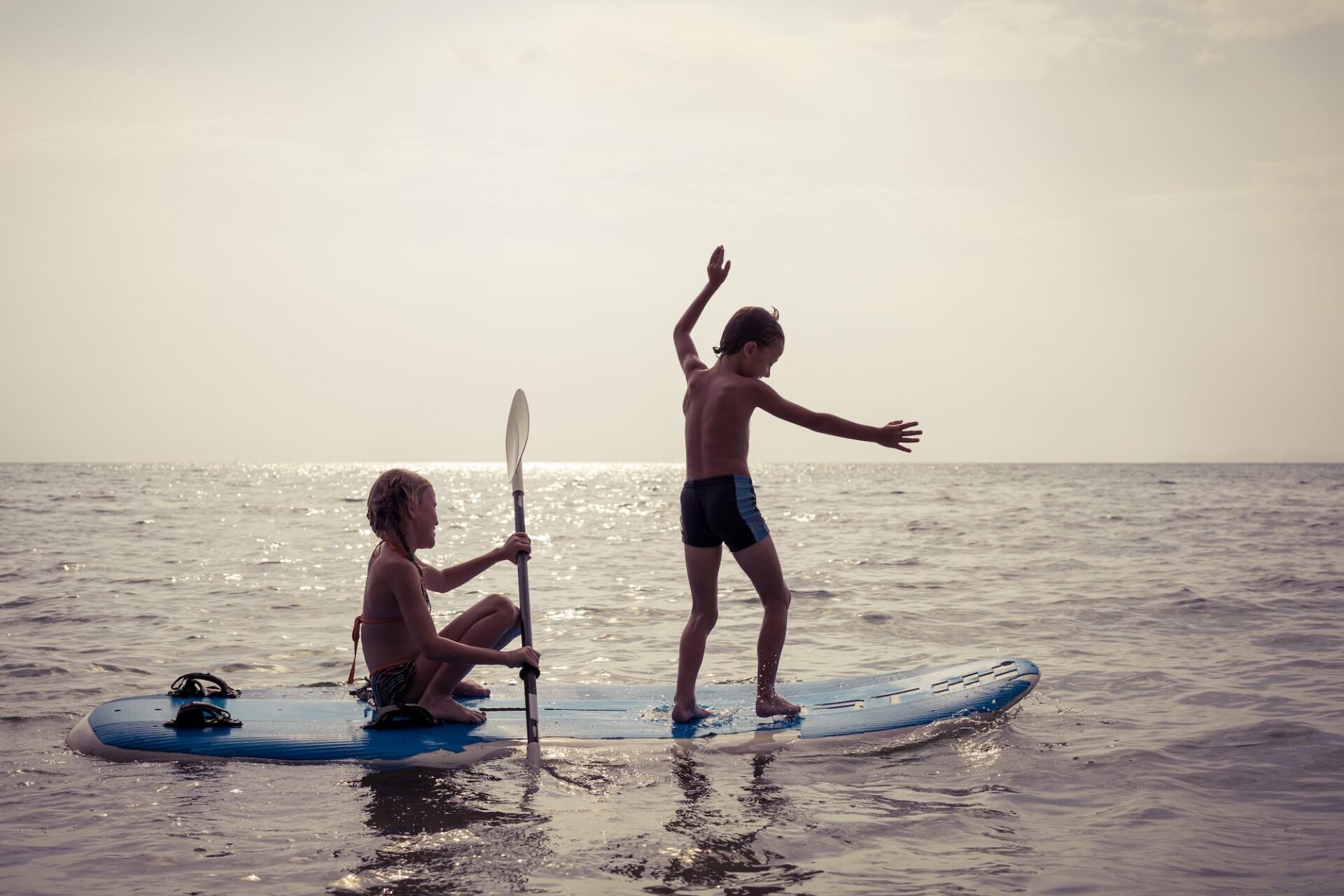 Happy children playing on the beach at the day time.Two Kids having fun outdoors. Concept of summer vacation and friendly family.